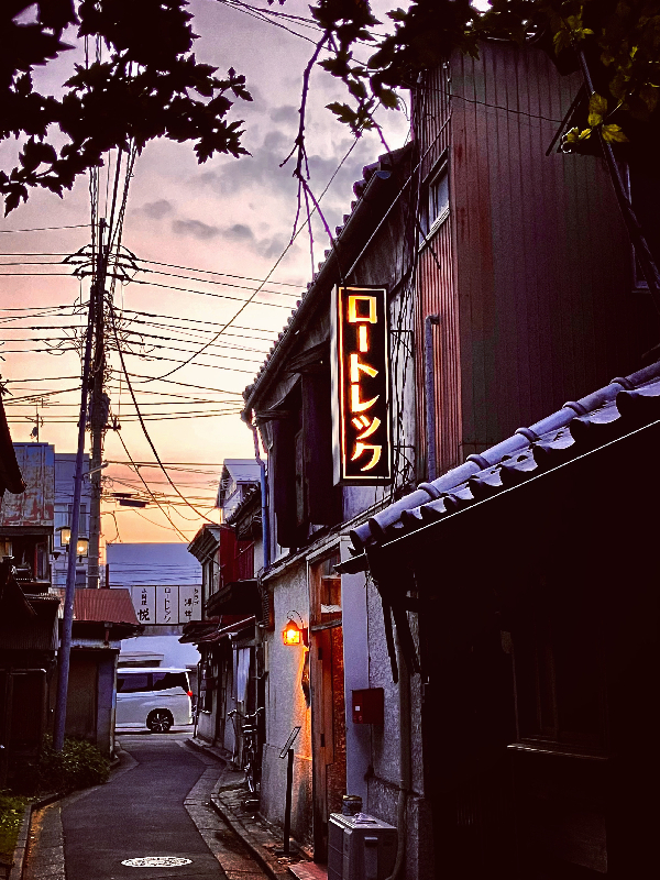 0425ロートレックの灯りと夕焼けの弁天横丁の写真